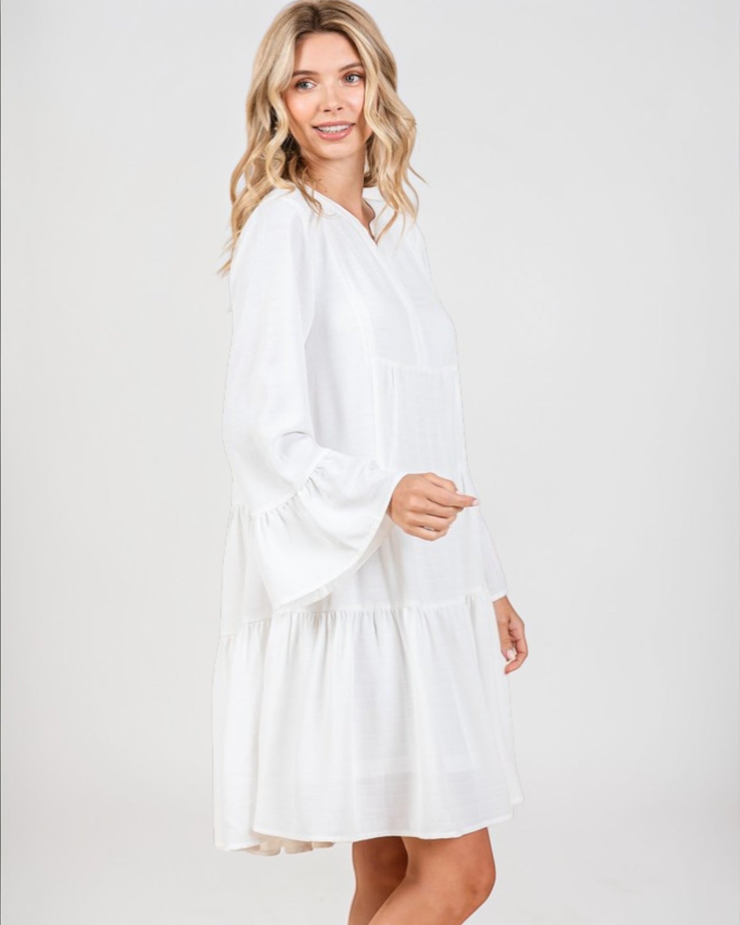 Woman wearing a white dress against a plain background