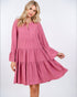 Woman wearing a pink dress with long sleeves on a white background