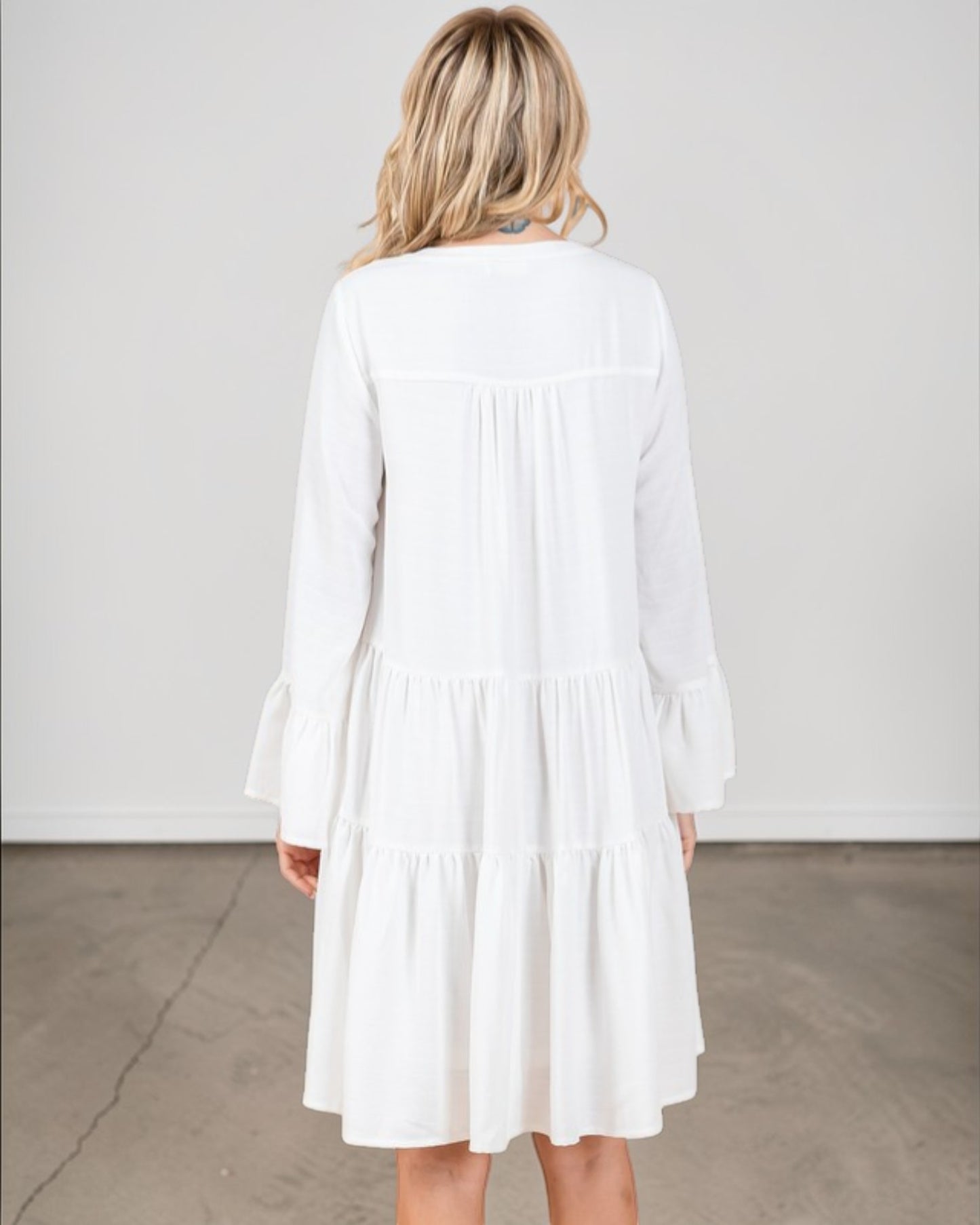 Woman wearing a white dress against a plain background