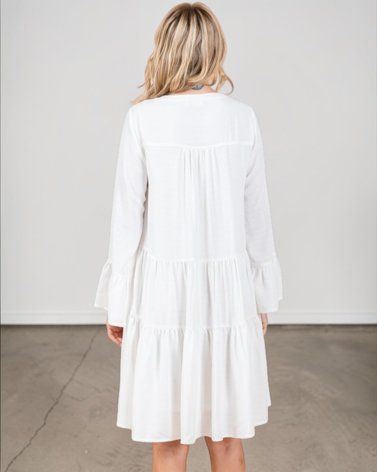 Woman wearing a white dress against a plain background