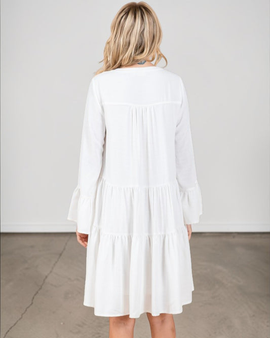 Woman wearing a white dress against a plain background