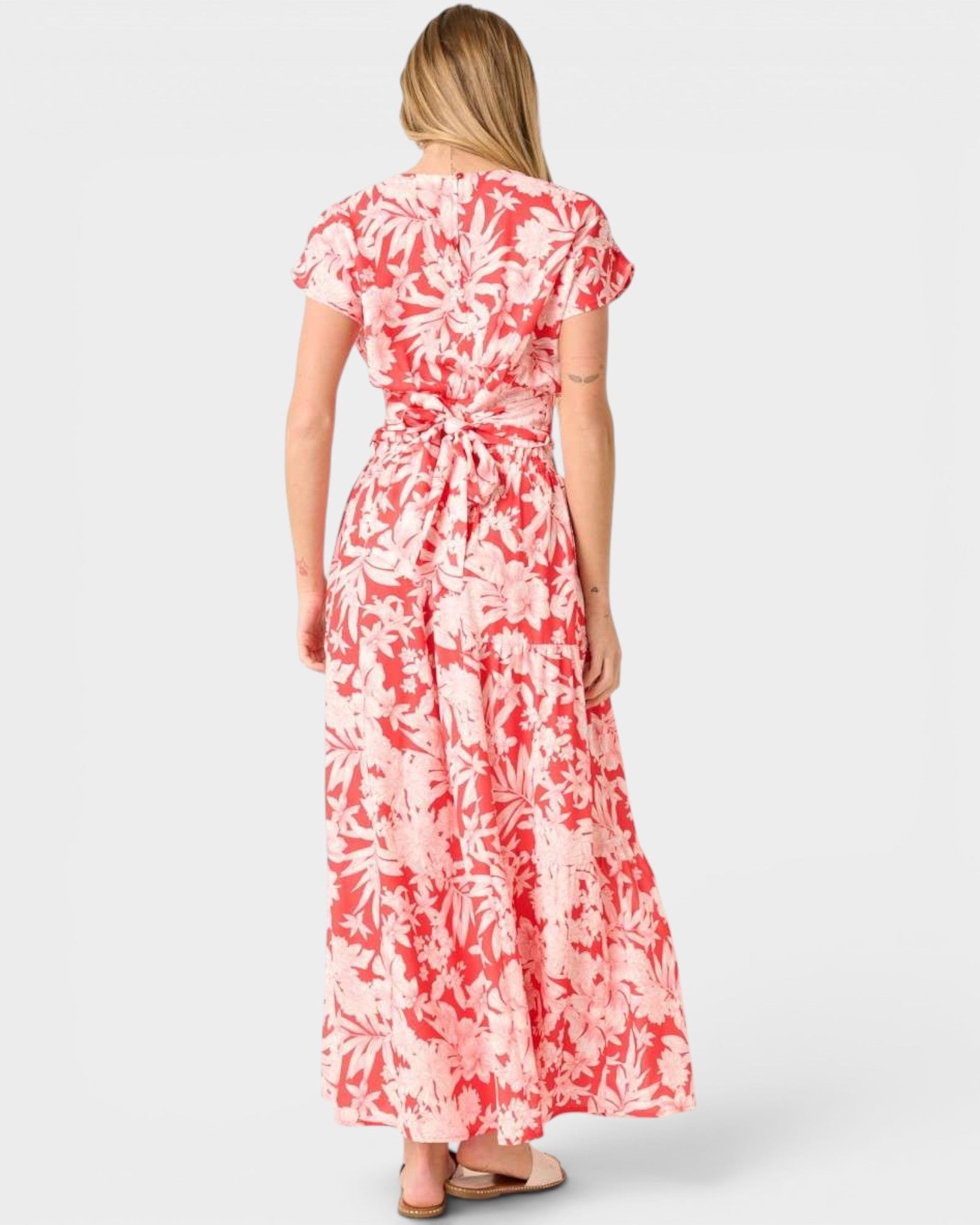 Woman wearing a red and white floral dress on a white background