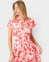 Woman wearing a red floral dress against a white background