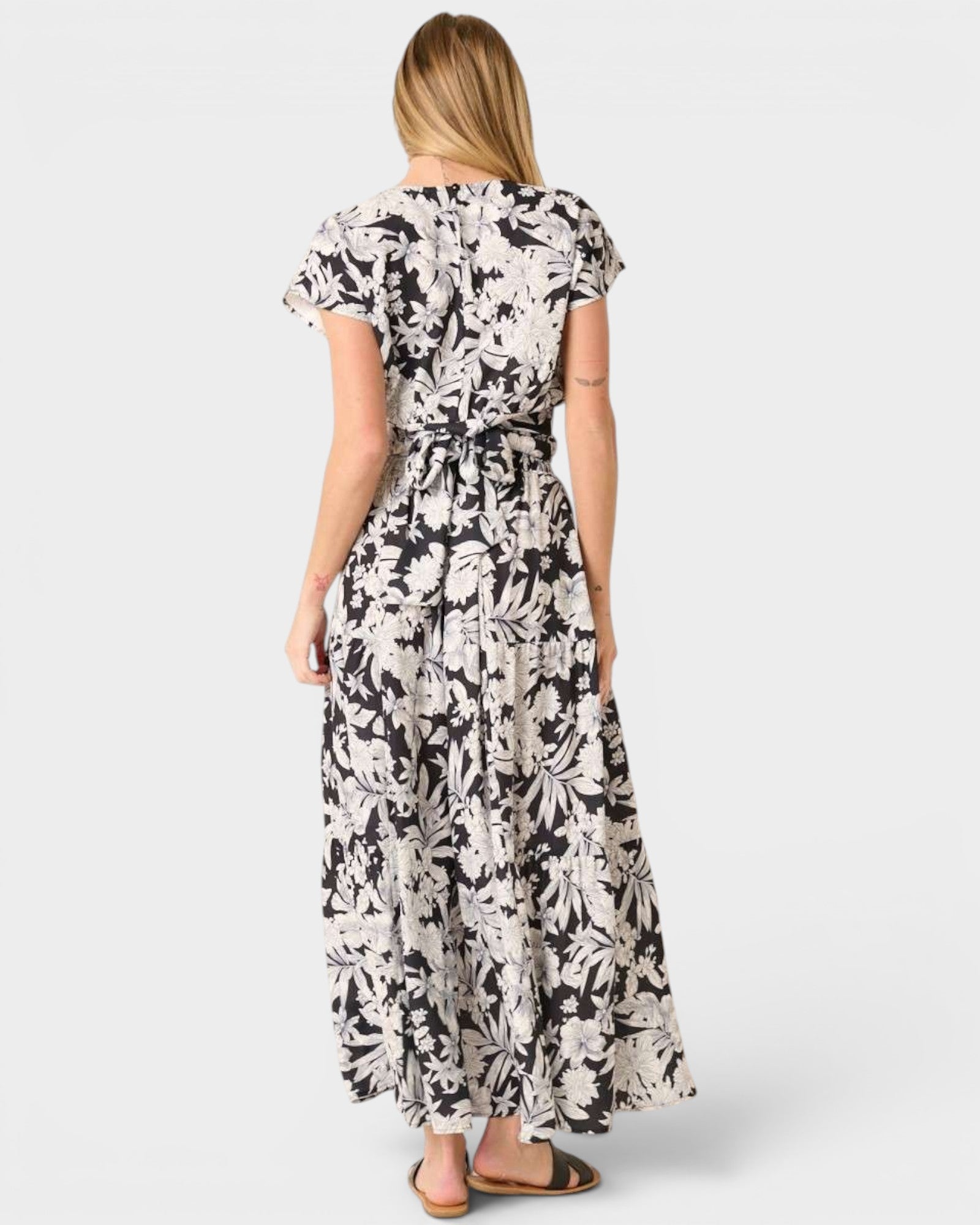 Woman wearing a black and white floral dress on a white background