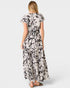 Woman wearing a black and white floral dress on a white background