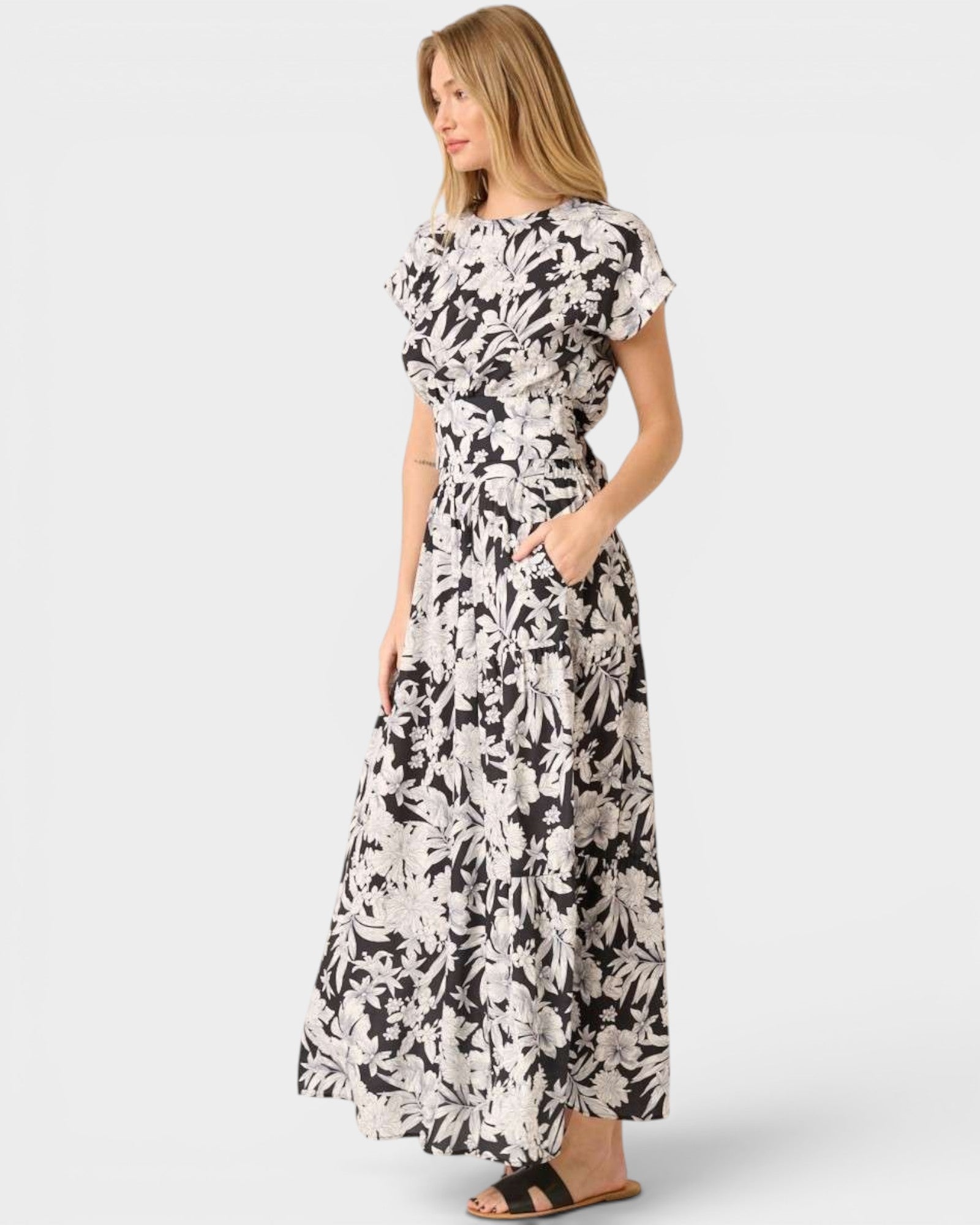 Woman wearing a black and white floral dress on a white background