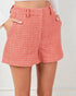 Red plaid shorts worn by a person on a white background