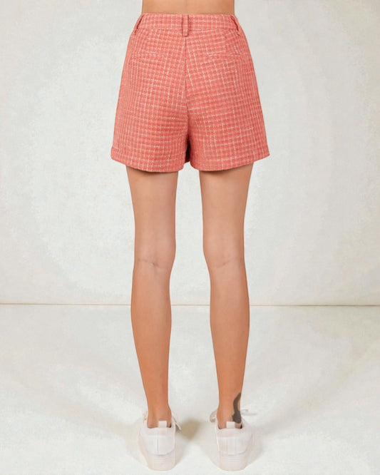 Person wearing pink plaid shorts on a white background