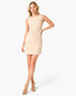 A woman modeling a sleeveless, knee-length beige and white textured tweed dress with a subtle grid pattern, paired with clear high-heeled sandals, against a plain white studio background.