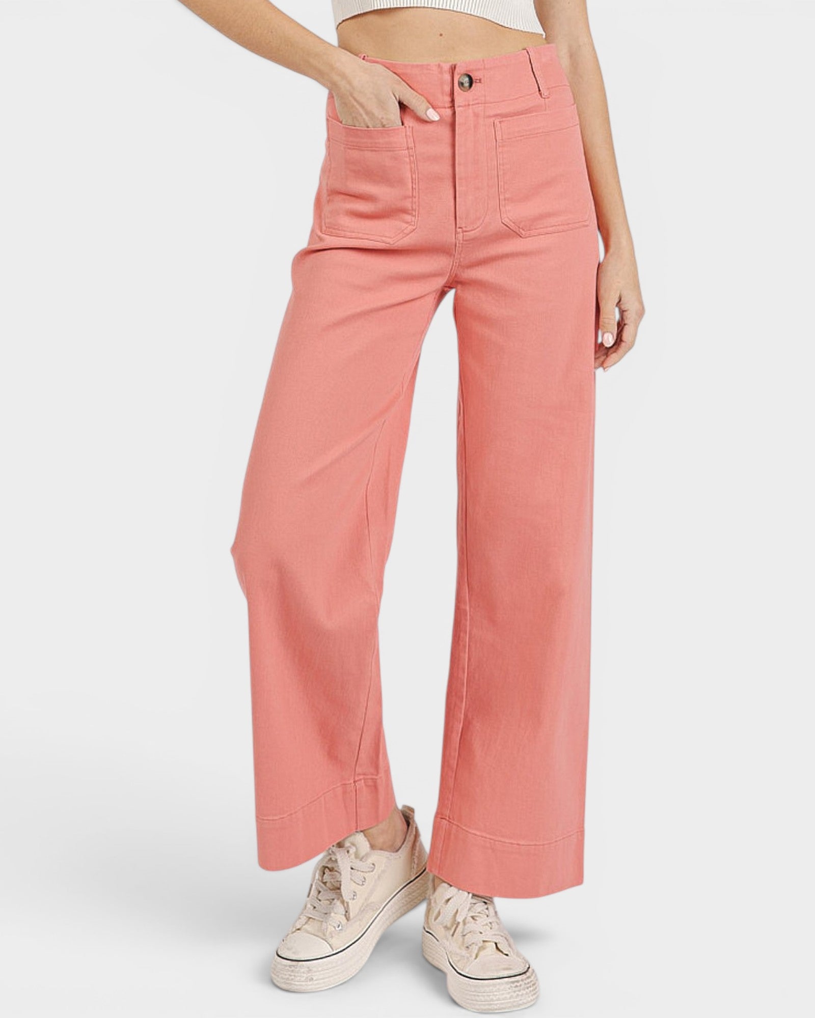 Person wearing coral pink pants with a white background