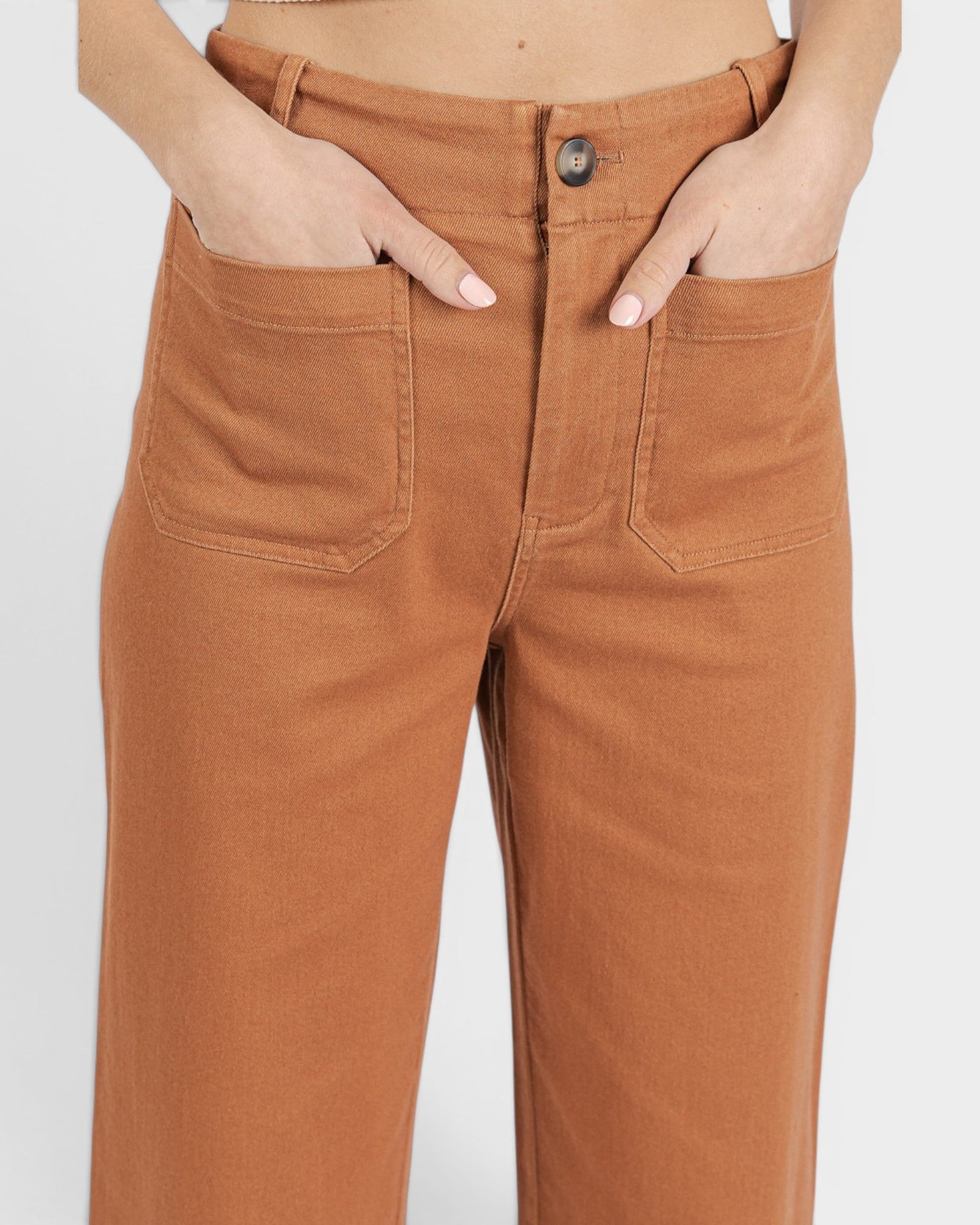 Brown pants worn by a person on a white background