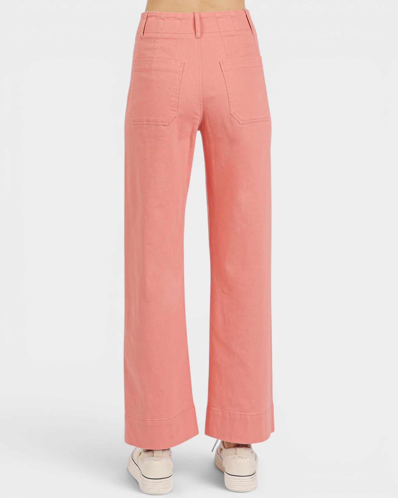 Coral pants worn by a person on a white background