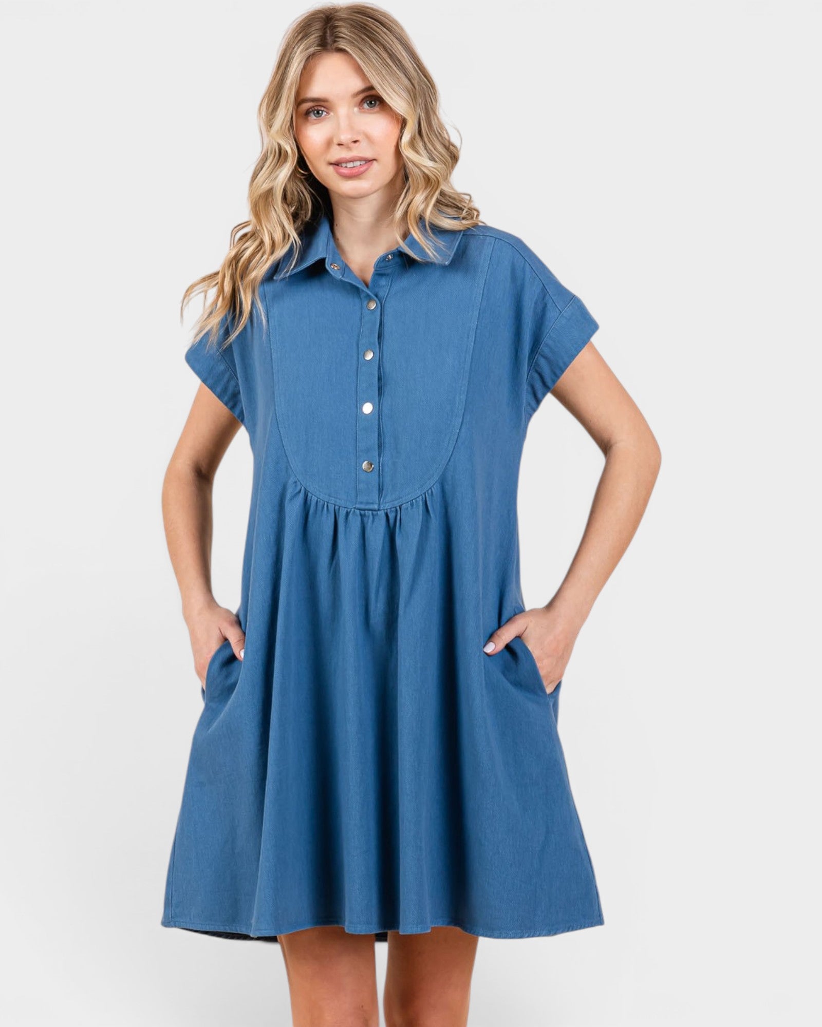 Woman wearing a blue dress with short sleeves on a white background