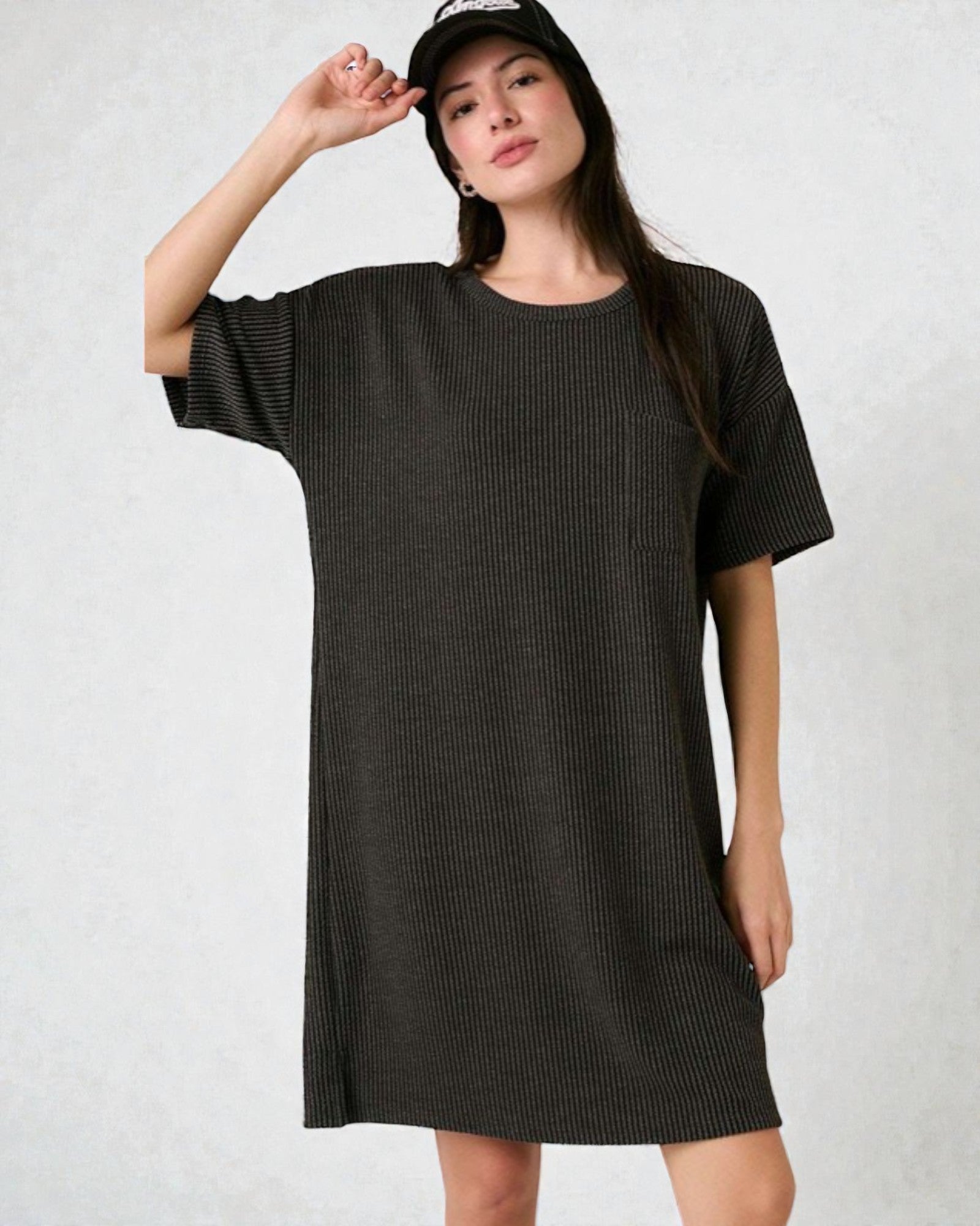 Woman wearing a dark gray textured dress against a white background