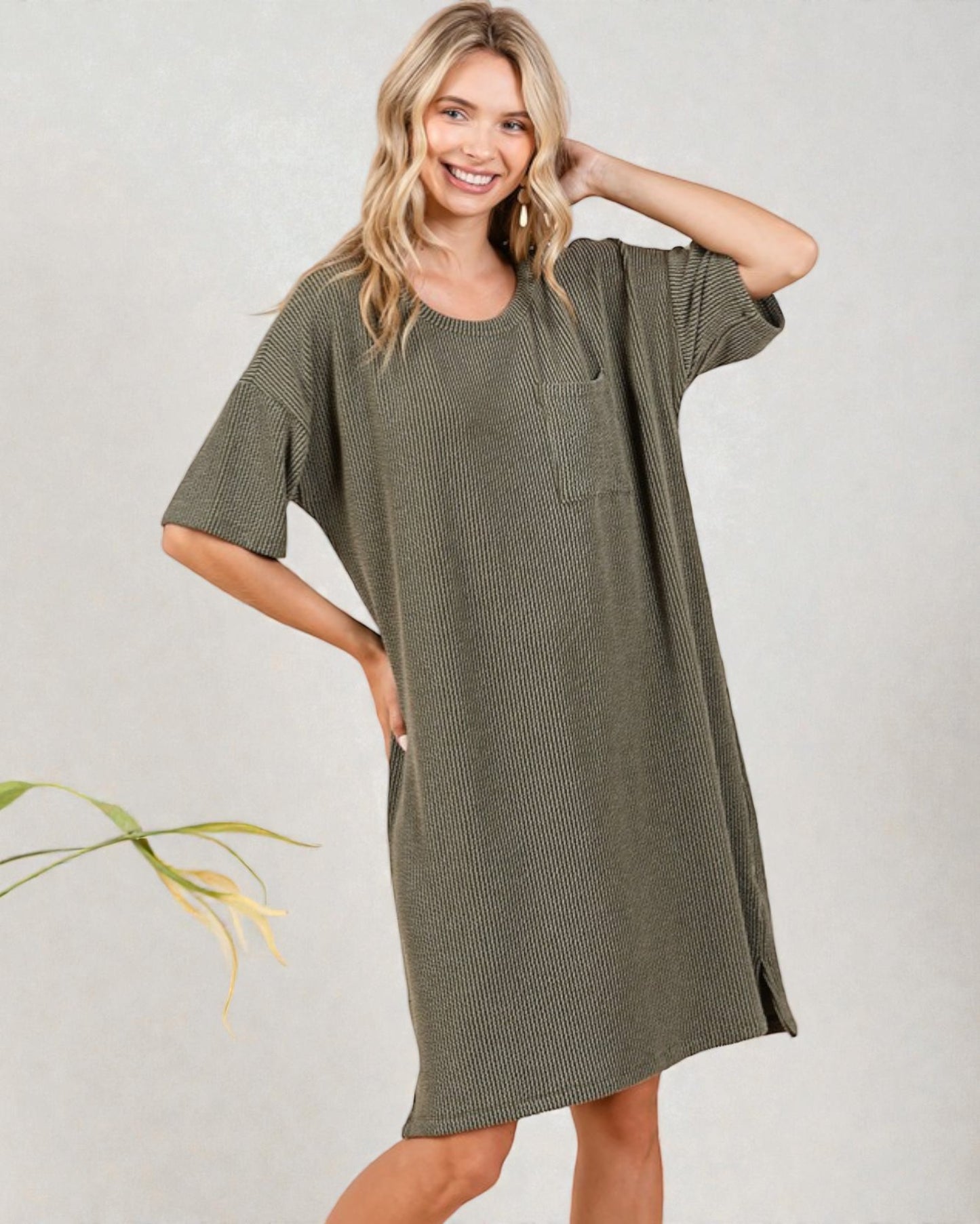 Woman wearing a green dress with a plain background