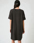 Person wearing a black t-shirt dress and cap on a white background