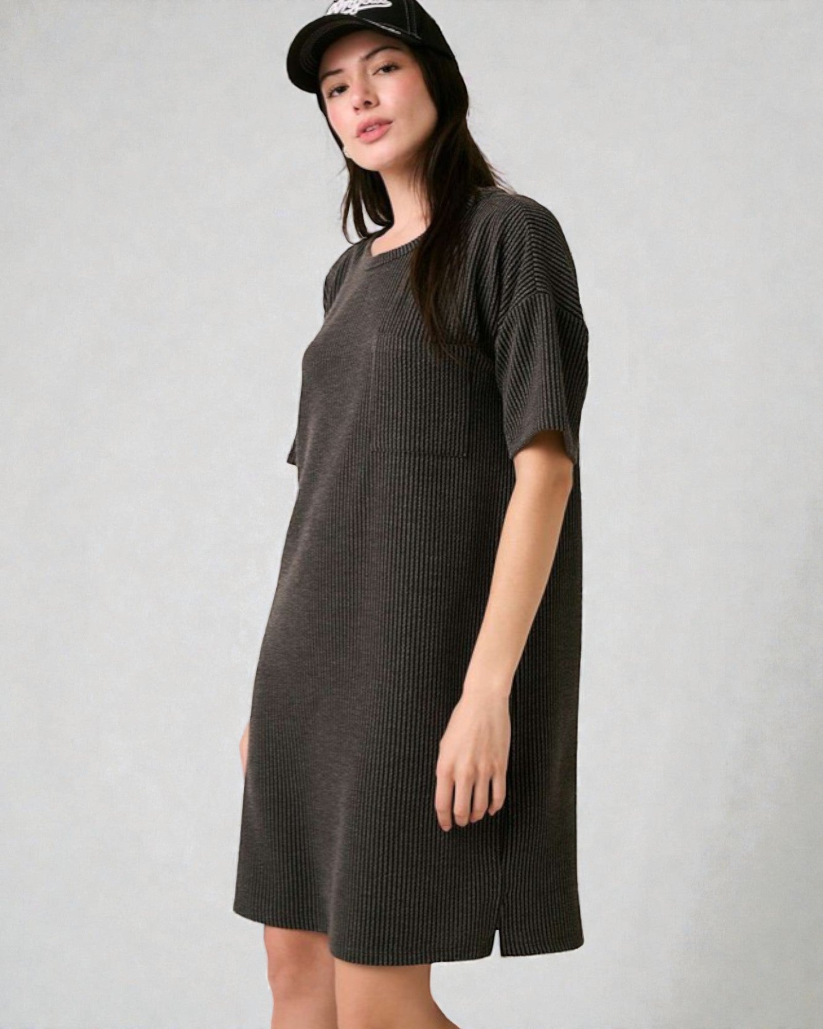 Woman wearing a dark gray dress against a plain background