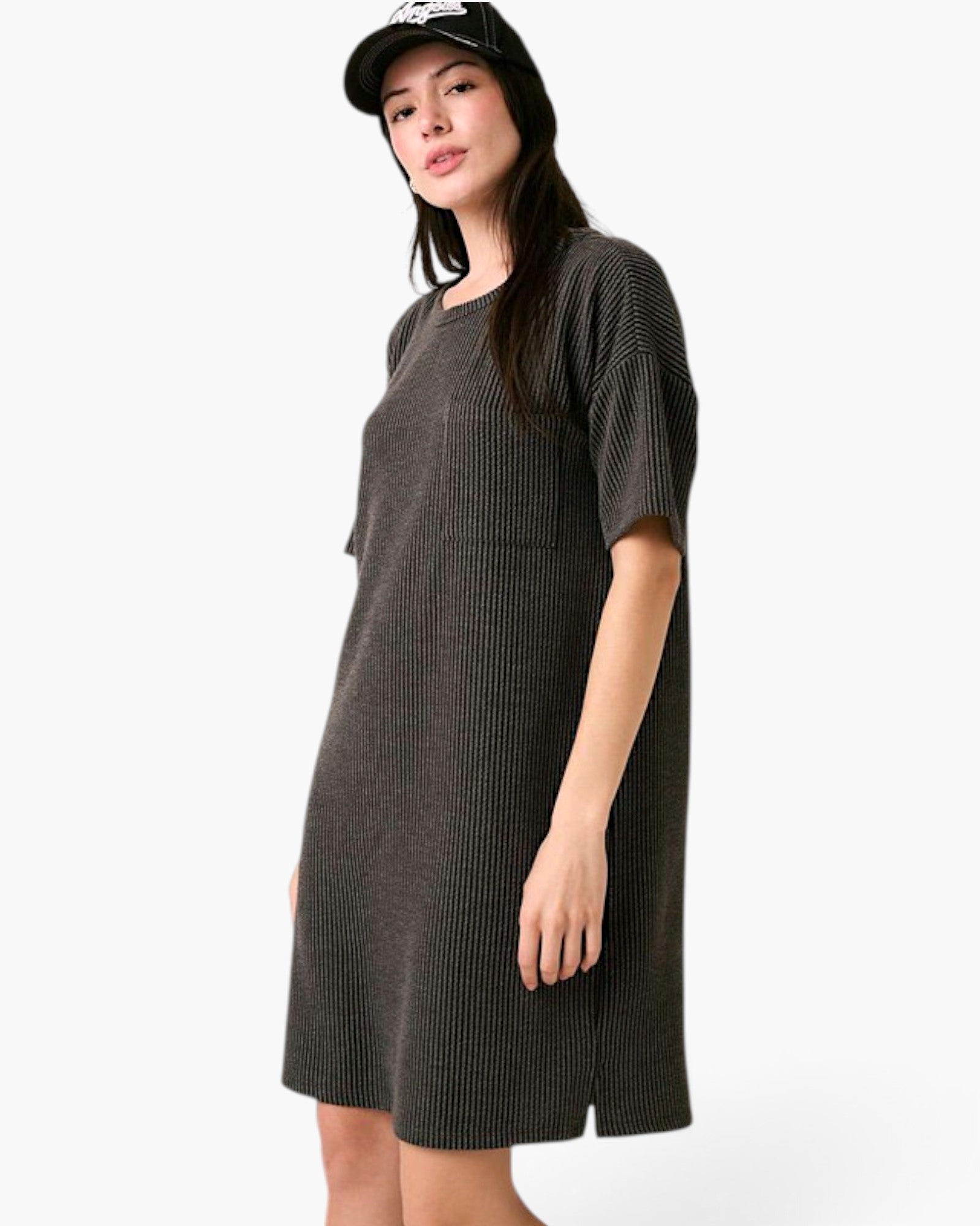 A woman modeling a dark gray ribbed short-sleeve dress and a black baseball cap against a plain white studio background.