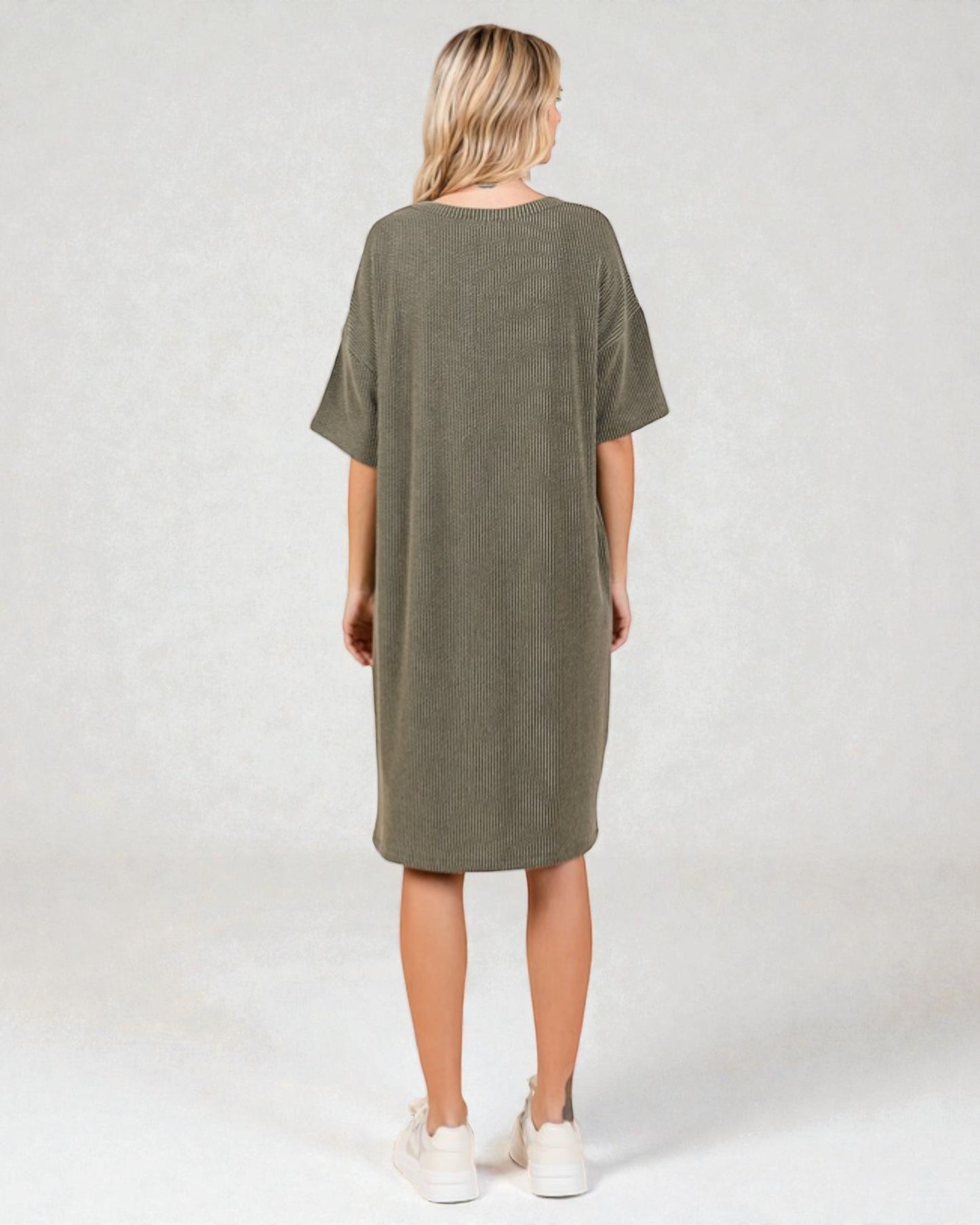 Person wearing an olive green dress on a white background