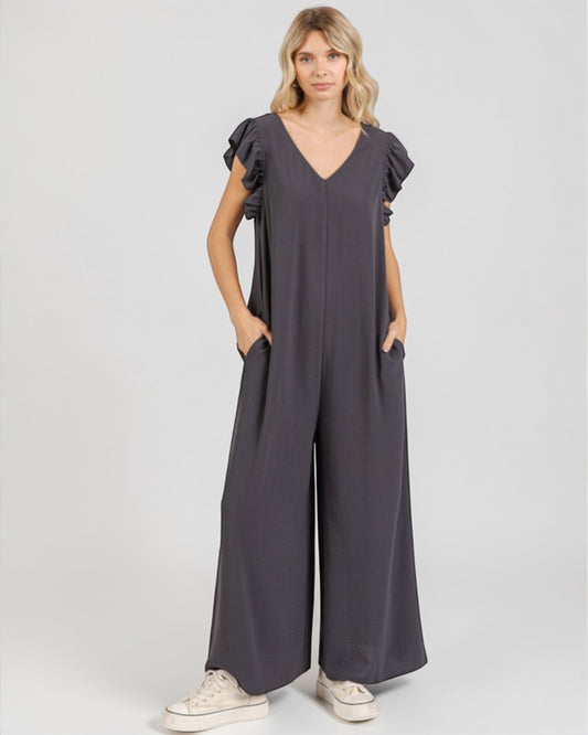 Woman wearing a dark gray jumpsuit on a white background