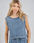 Woman wearing a denim sleeveless top against a plain background