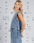 Woman wearing a denim outfit with a patterned background