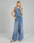 Woman wearing a denim sleeveless top and wide-leg pants on a gray background