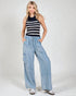 Woman wearing a striped tank top and wide-leg jeans on a white background