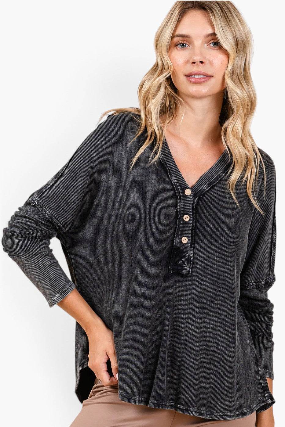 A woman wearing a dark gray mineral-wash long-sleeve henley top with a button placket, shown against a plain white background.