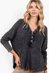 A woman wearing a dark gray mineral-wash long-sleeve henley top with a button placket, shown against a plain white background.