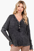 A woman modeling a dark gray washed long-sleeve henley top with a button placket, paired with tan pants, against a plain white background.