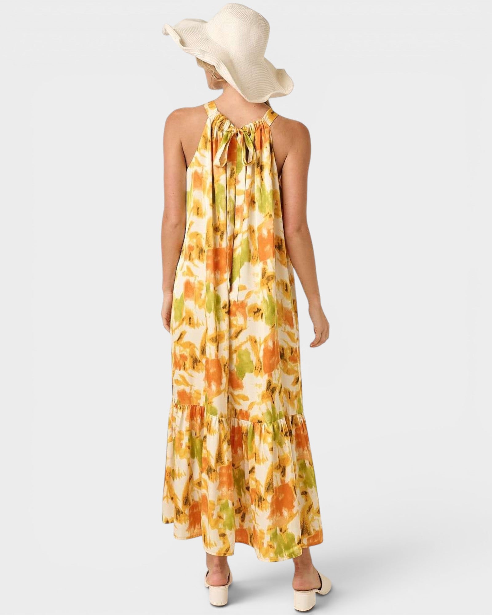 Woman wearing a colorful dress and wide-brimmed hat on a white background