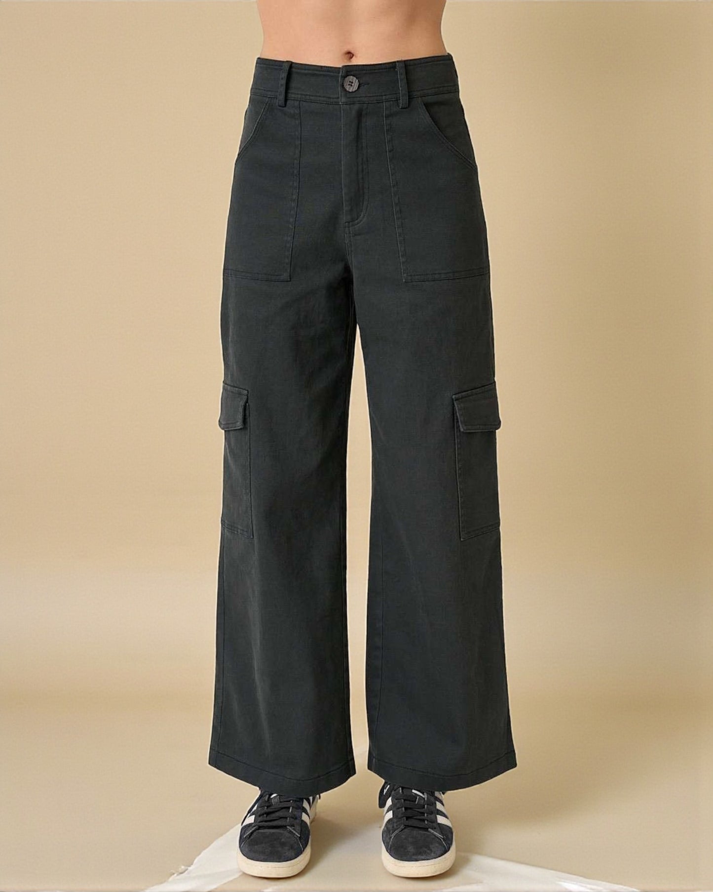 Black cargo pants worn by a person on a beige background