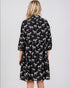 Black dress with white zebra pattern worn by a person on a light gray background