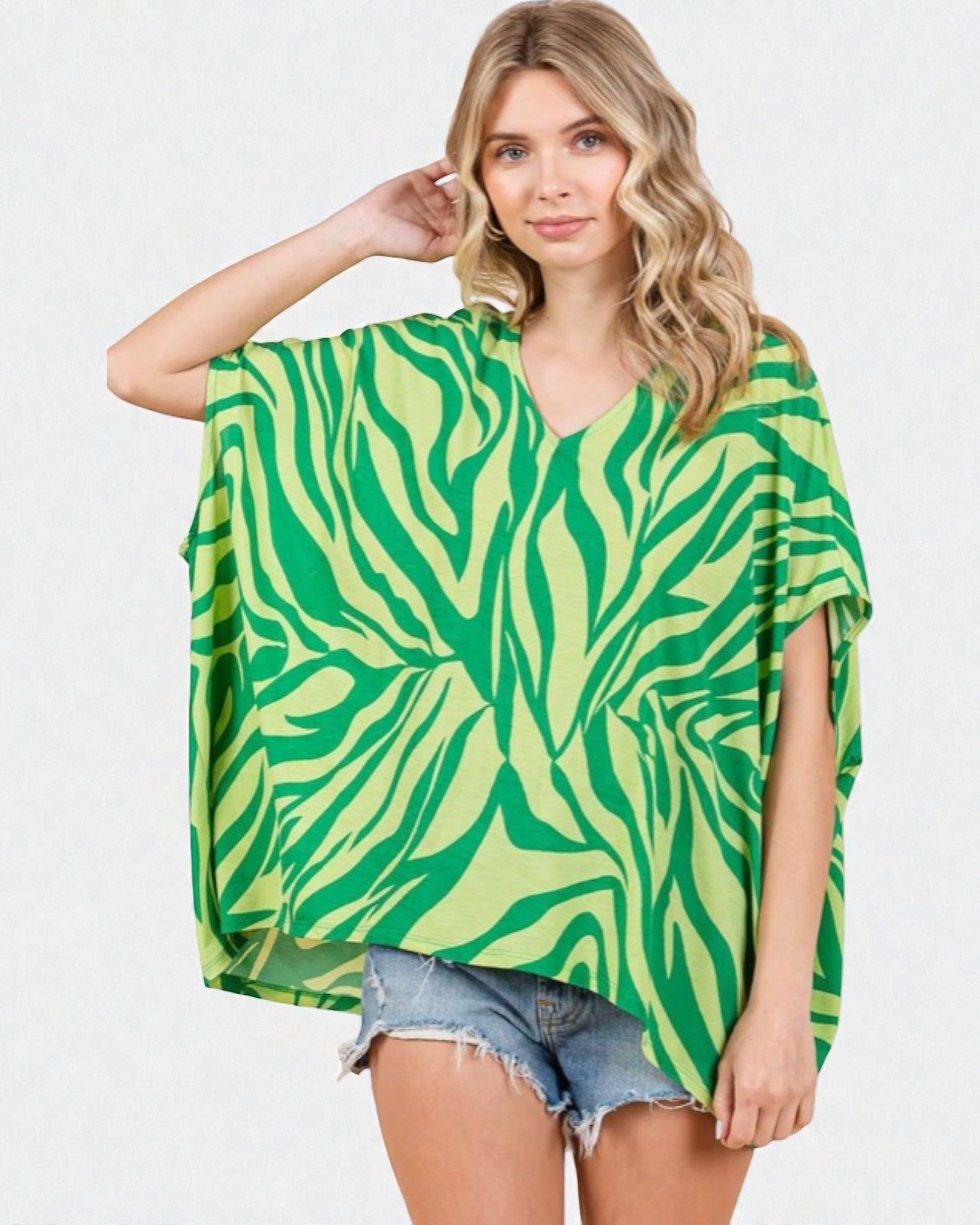 Woman wearing a green and yellow patterned top on a white background