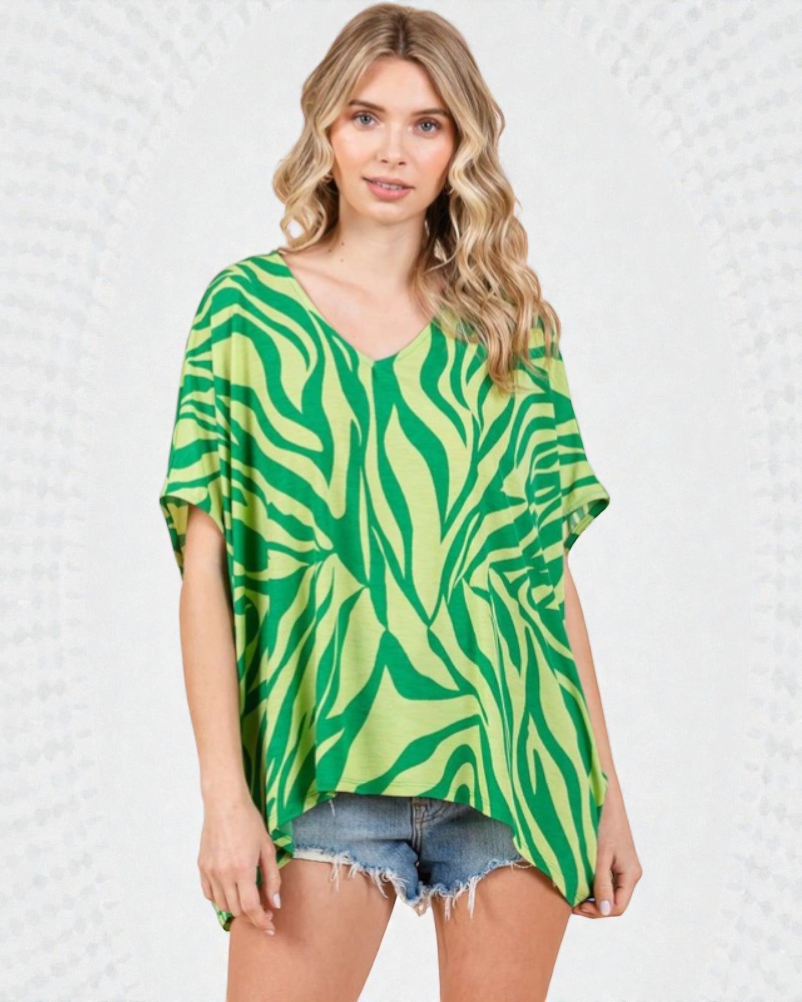Woman wearing a green and white patterned top on a white background