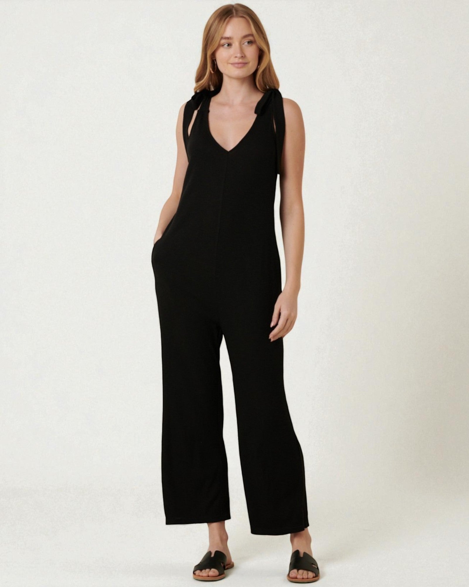 Woman wearing a black jumpsuit on a white background