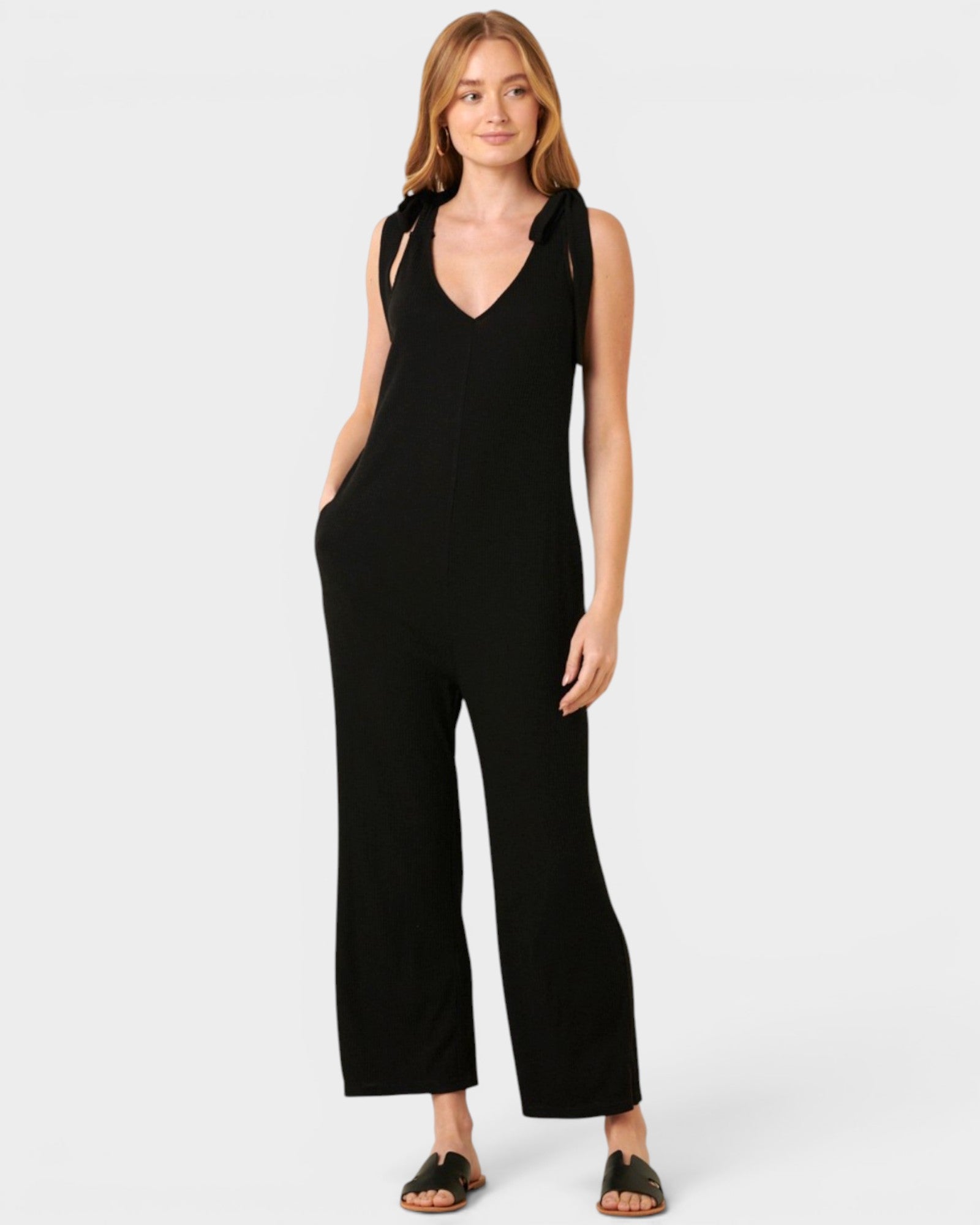Woman wearing a black jumpsuit on a white background