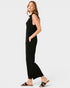 Woman wearing a black sleeveless jumpsuit on a white background
