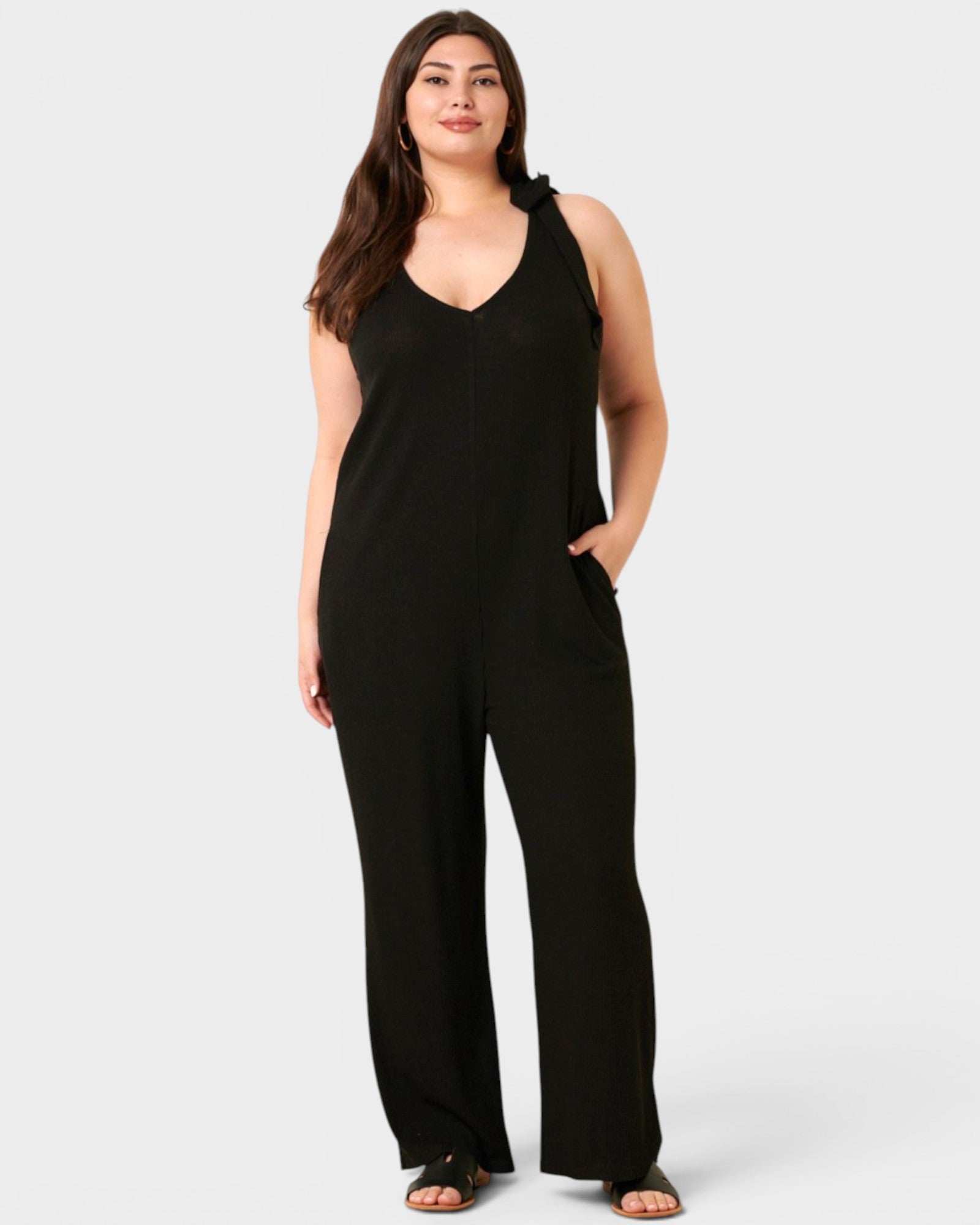 Woman wearing a black jumpsuit on a white background