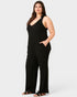 Woman wearing a black sleeveless jumpsuit on a white background