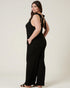 Woman wearing a black jumpsuit with a bow detail on a white background
