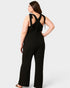 Woman wearing a black jumpsuit with open back on a white background