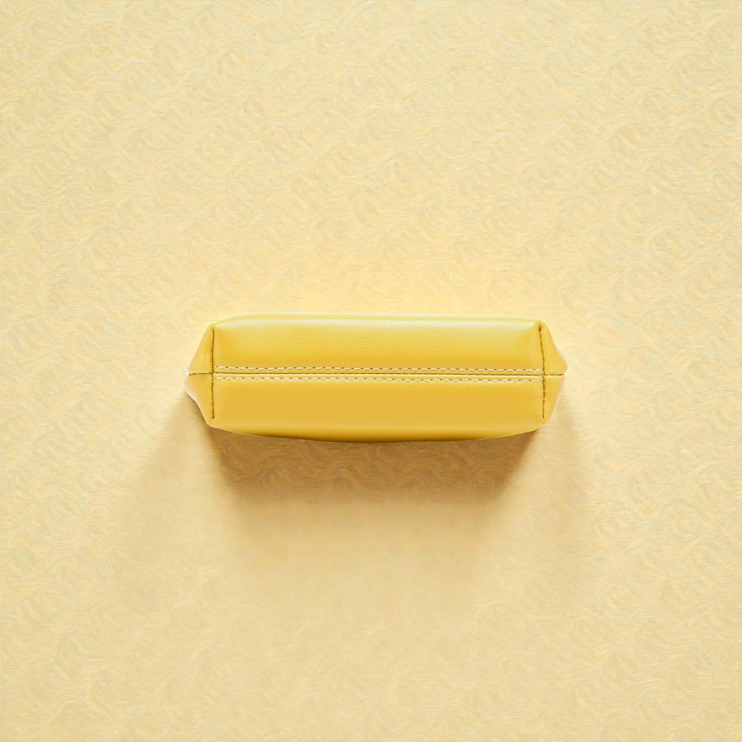 Yellow rectangular object on a textured beige background