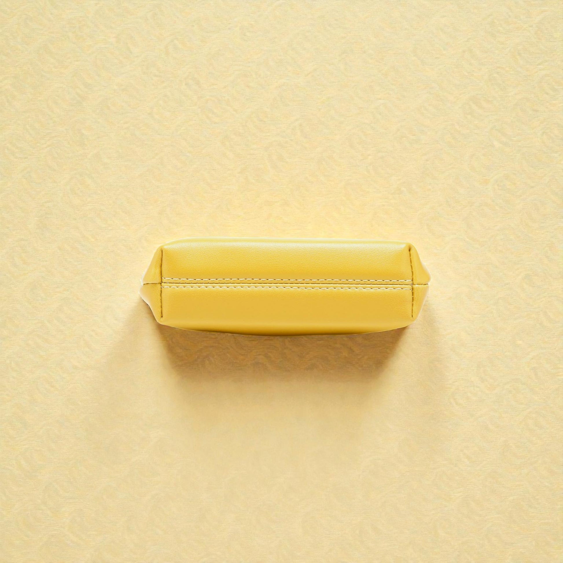 Yellow rectangular object on a textured beige background