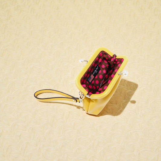 Yellow pouch with a polka dot interior on a beige background