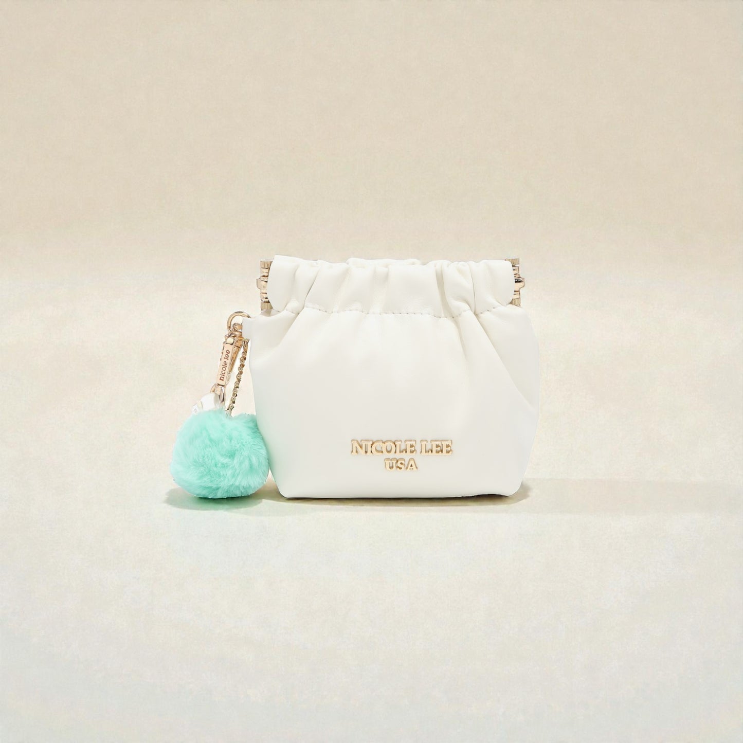 White pouch with a turquoise pom-pom on a beige background
