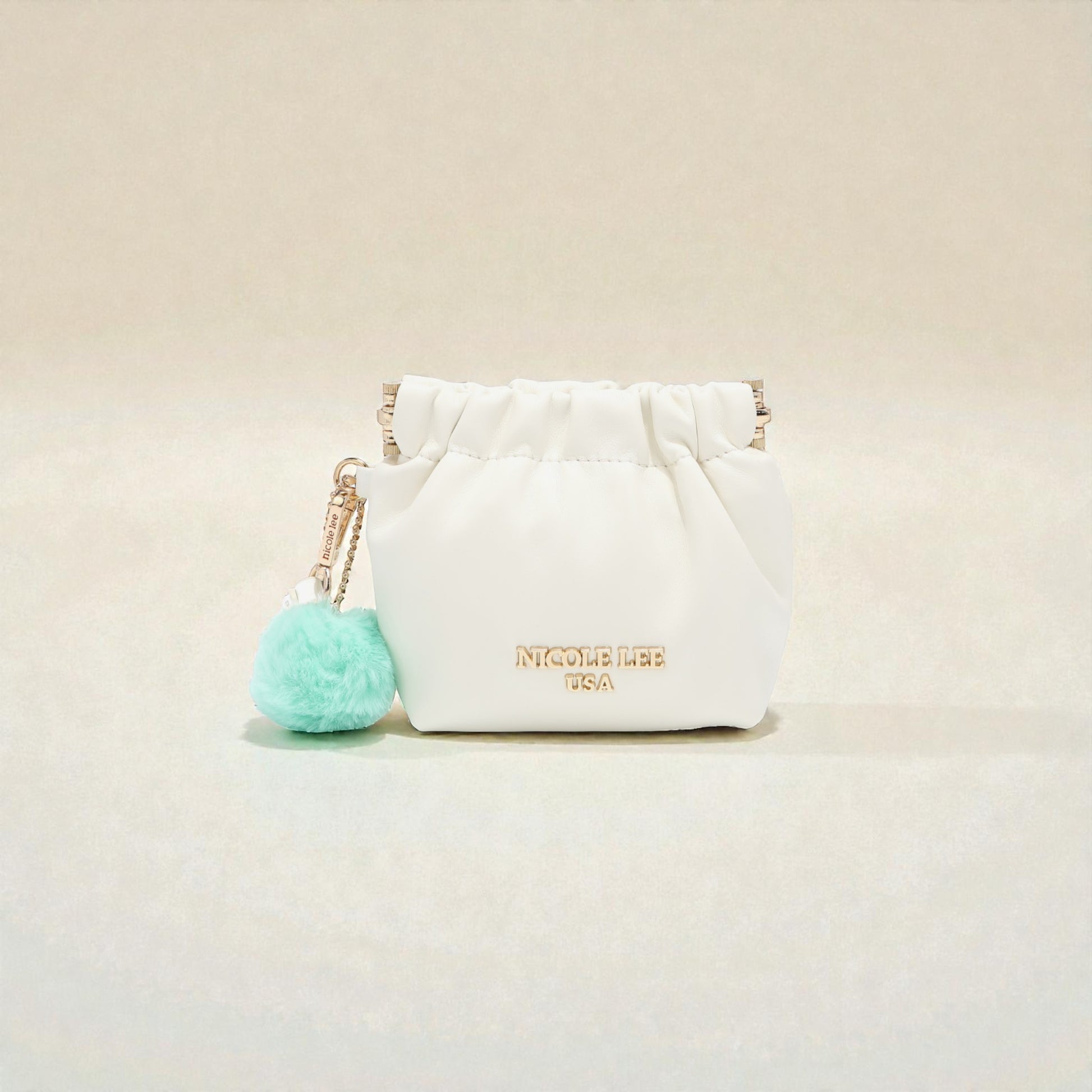White pouch with a turquoise pom-pom on a beige background
