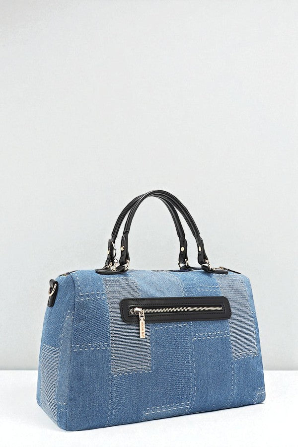 Blue denim handbag with black handles and zipper on a white background