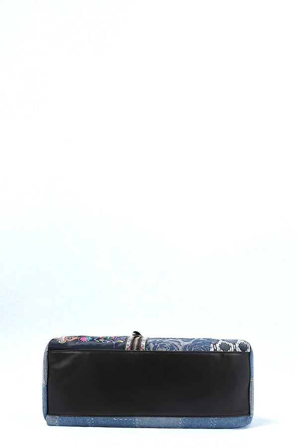 Black clutch bag with floral pattern on a light blue background